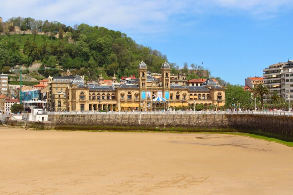 Das monumentale, sandsteinfarbene Rathaus von San Sebastián, das ehemalige Casino von 1887, direkt hinter dem breiten Sandstrand der Concha-Bucht.