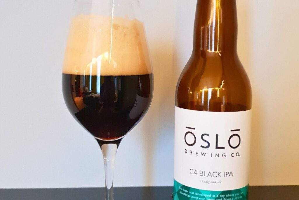 Eine Flasche der lokalen Brauerei Oslo Brewing Co. neben einem passenden Glas mit dunklem Bier.