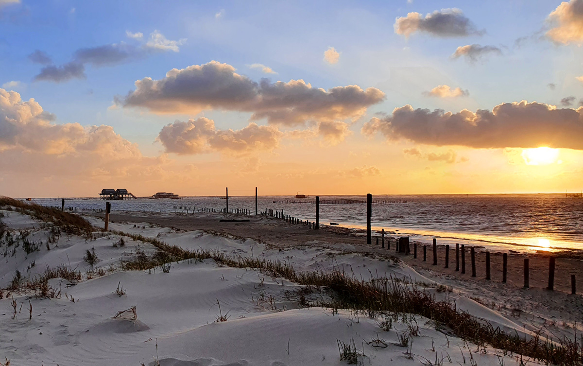 Die Pfahlbauten sind die malerischen St. Peter-Ording Sehenswürdigkeiten, die man sich bei Sonnenuntergang anschauen sollte