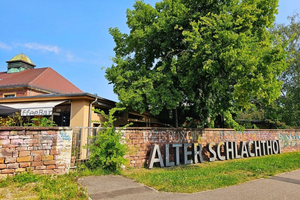 Eingang zum Alten Schlachthof Karlsruhe mit großem Schriftzug und Café-Bar