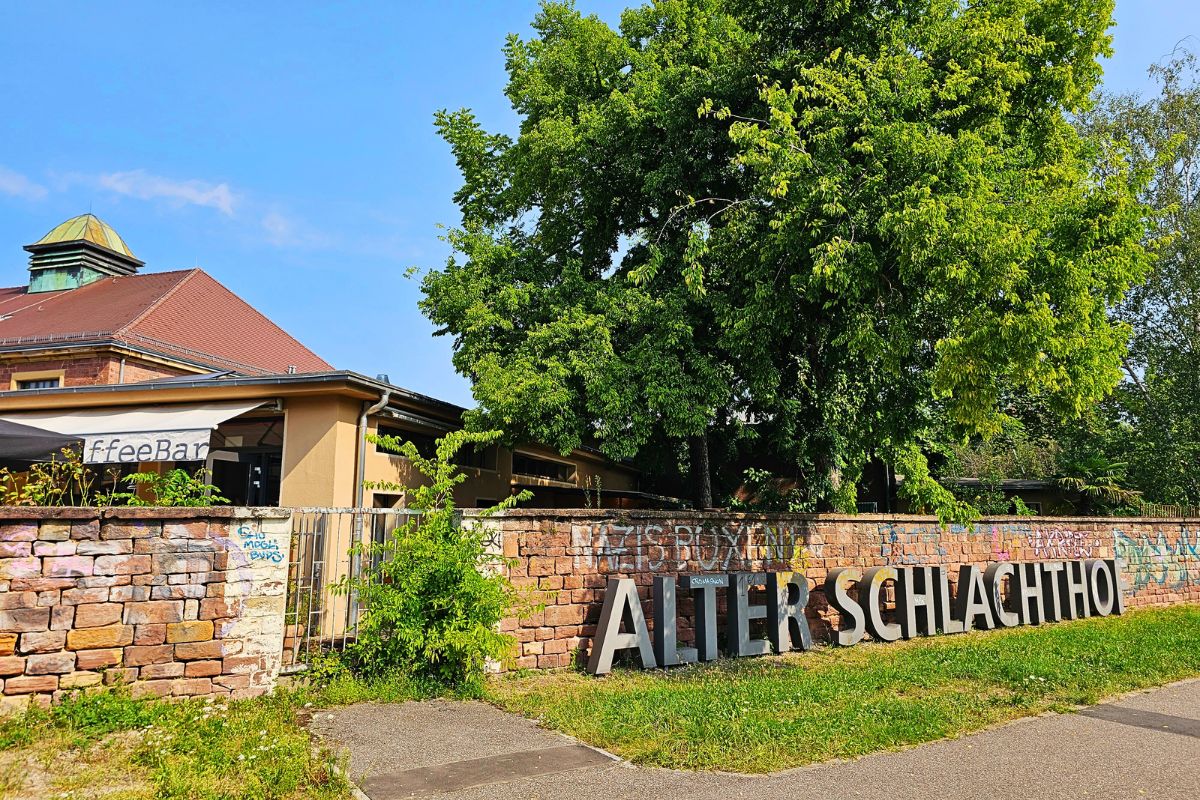 Eingang zum Alten Schlachthof Karlsruhe mit großem Schriftzug und Café-Bar
