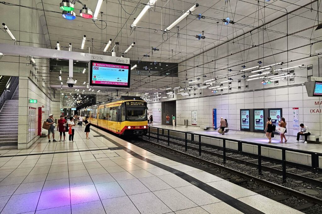Straßenbahn an Bahnsteig im unterirdischen Bahnhof Marktplatz Karlsruhe mit Fahrgästen