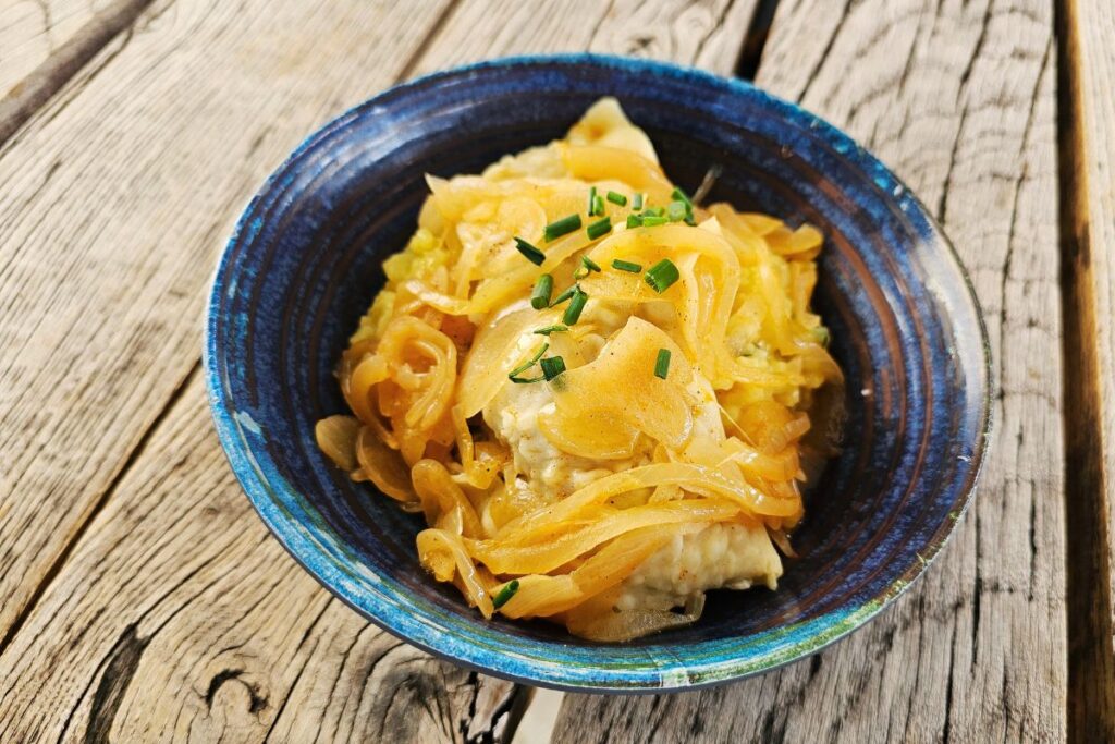 Badische Maultaschen mit geschmorten Zwiebeln in Schale serviert