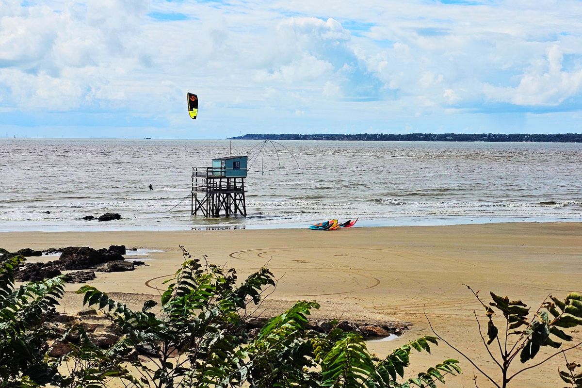 Strand mit Fischerhütte und Kitesurfer an der französischen Atlantikküste