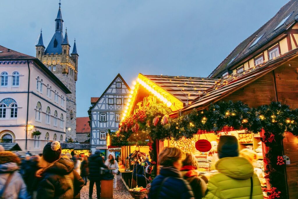 Dichtes Gedränge auf dem Altdeutschen Weihnachtsmarkt in Bad Wimpfen vor Fachwerkhäusern und dem Blauen Turm.
