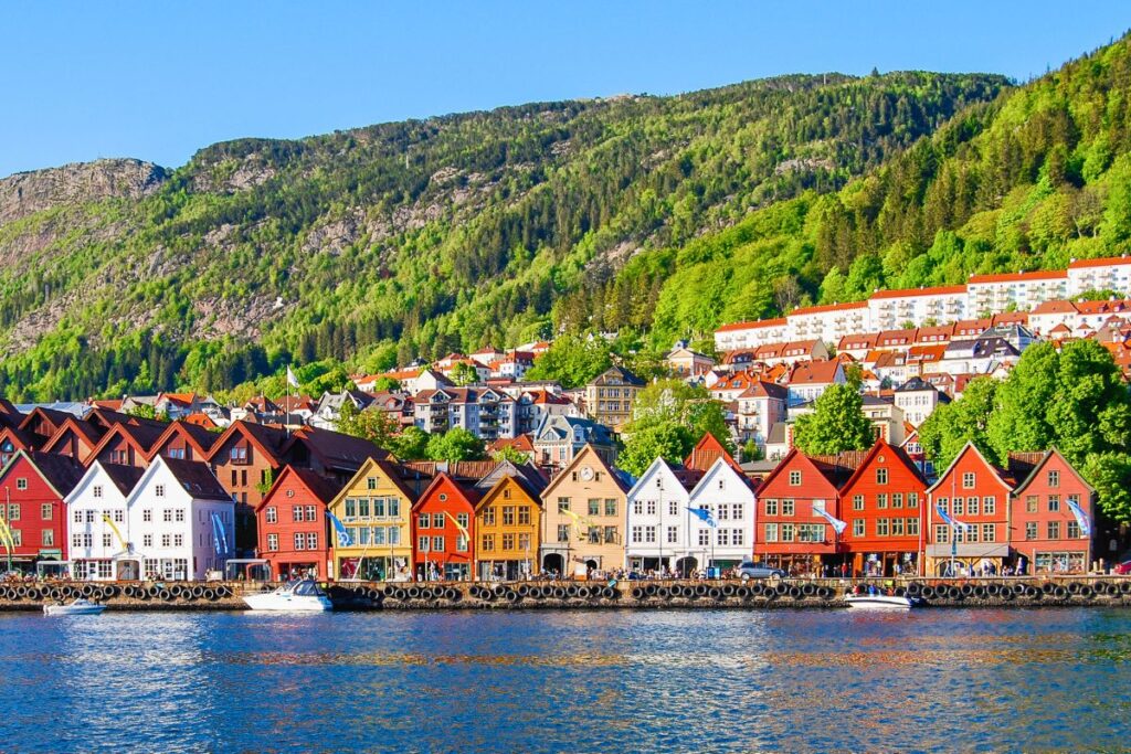 Historische Hansehäuser von Bryggen in Bergen vor grünem Berghang