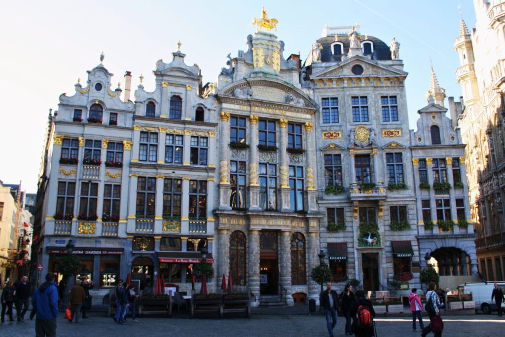 Historische Fassaden am Grand Place in Brüssel, Belgien, mit goldverzierten Gebäuden und Passanten