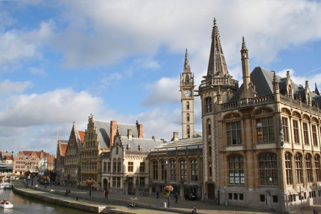 Graslei in Gent mit historischen Giebelhäusern am Kanal unter blauem Himmel