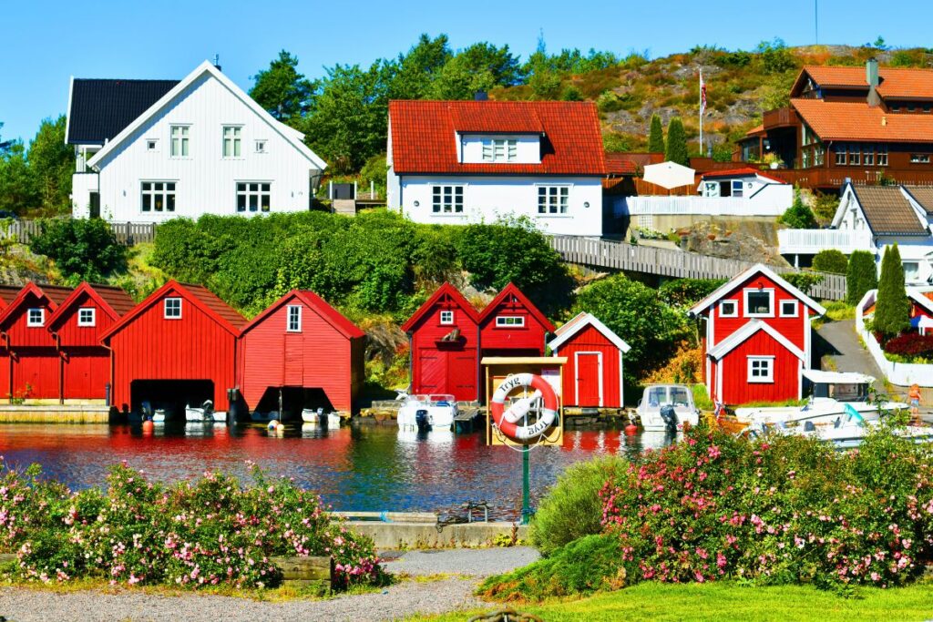 Rote Bootshäuser und weiße Holzhäuser am Wasser in Kristiansand