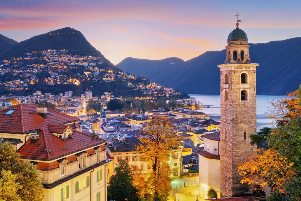 Lugano bei Sonnenuntergang mit San-Lorenzo-Kirche, See und Berghängen