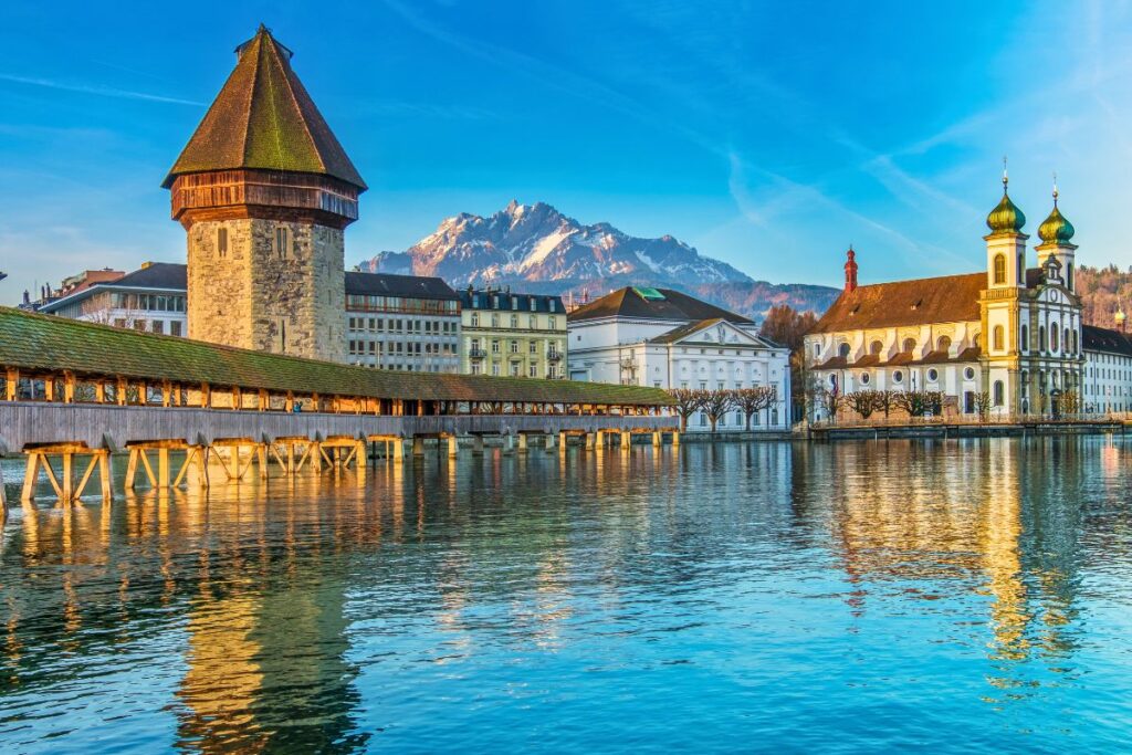 Kapellbrücke und Wasserturm in Luzern mit Alpen im Hintergrund
