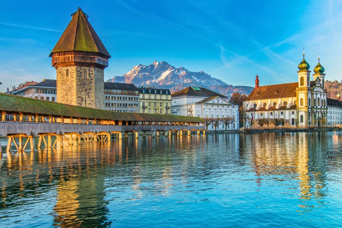 Kapellbrücke und Wasserturm in Luzern mit Alpen im Hintergrund