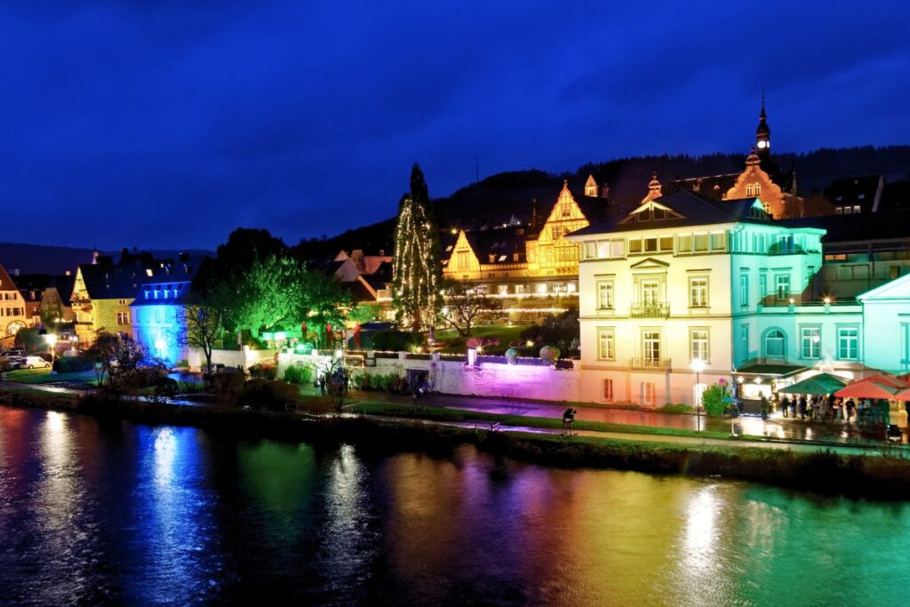 Bunt beleuchtete Gebäude und Uferpromenade in Traben-Trarbach an der Mosel zur Weihnachtszeit.