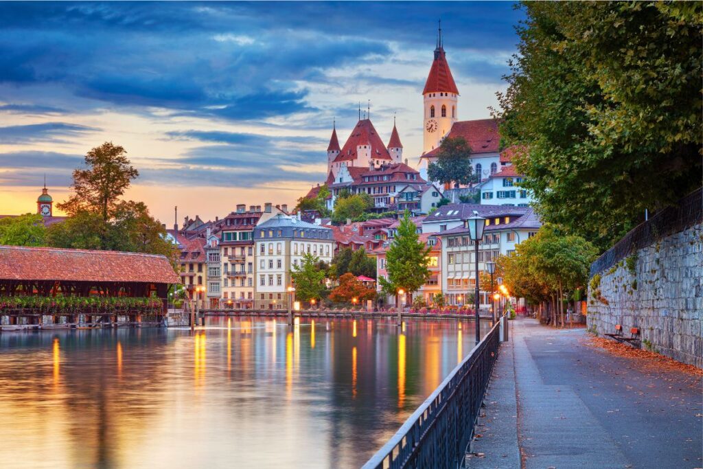 Schloss Thun über der Altstadt mit Aare und gedeckter Holzbrücke bei Abendstimmung