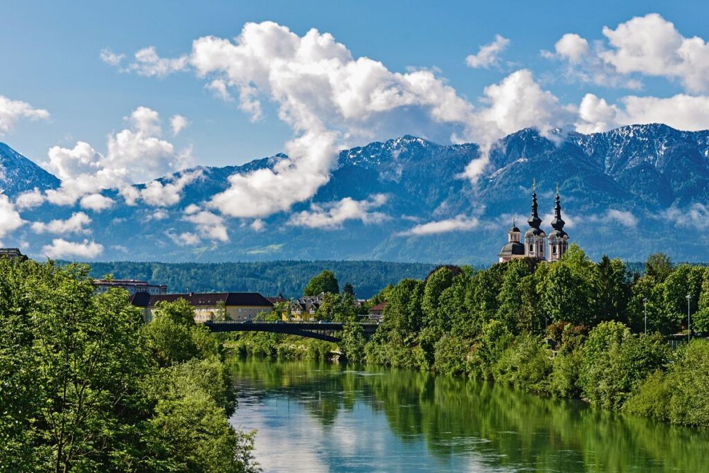 Villach an der Drau mit Alpenkulisse und barocker Kirche Maria Gail im Hintergrund