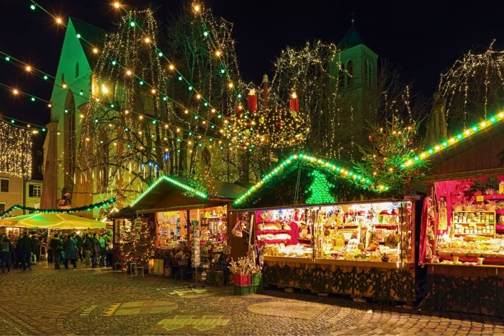 Weihnachtsmarkt in Freiburg im Breisgau mit bunten Ständen und Lichterketten in der Altstadt