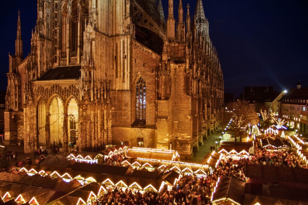Weihnachtsmarkt in Ulm mit festlich beleuchteten Ständen vor dem Ulmer Münster