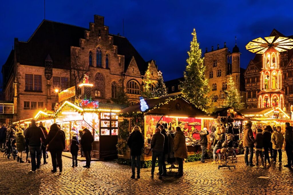Der Hildesheimer Weihnachtsmarkt mit Pyramide und Buden vor der prächtigen Fachwerkkulisse.