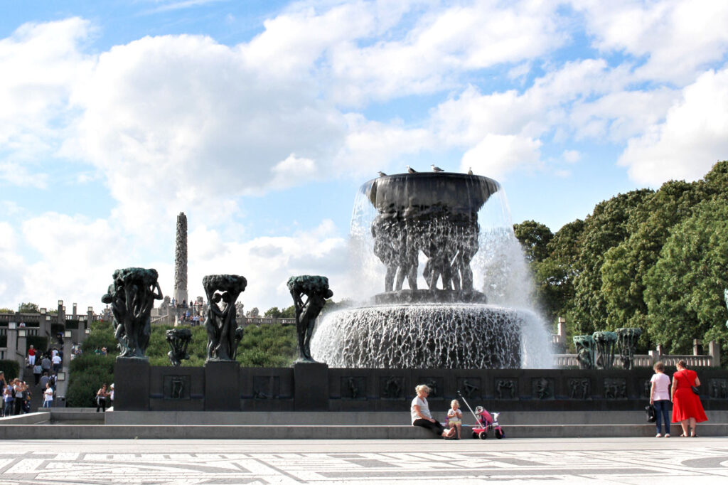 Der große Bronzebrunnen im Vigeland Park, getragen von sechs Riesen, mit sprudelndem Wasser unter blauem Himmel