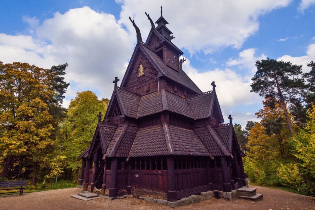 Die dunkle hölzerne Stabkirche von Gol mit Drachenschnitzereien im Norsk Folkemuseum auf Bygdøy unter blauem Himmel