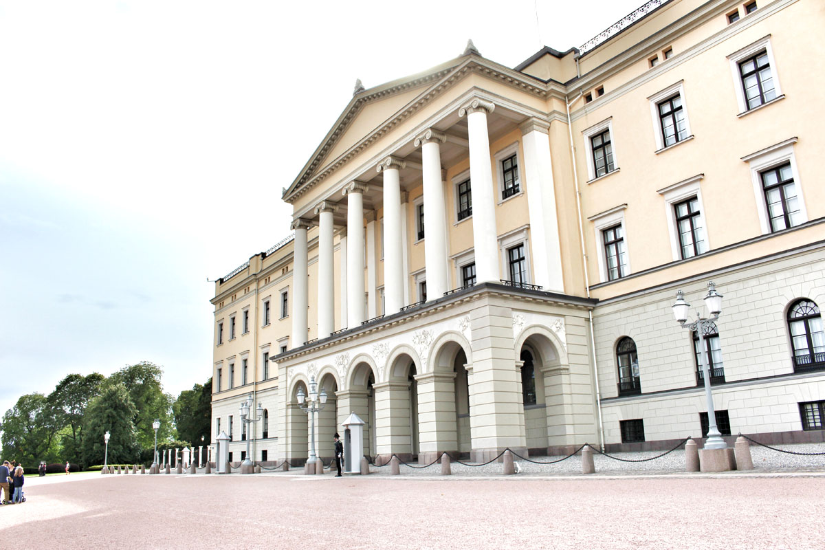 Seitenansicht des Königlichen Schlosses in Oslo mit seinen imposanten weißen Säulen und der hellgelben Fassade