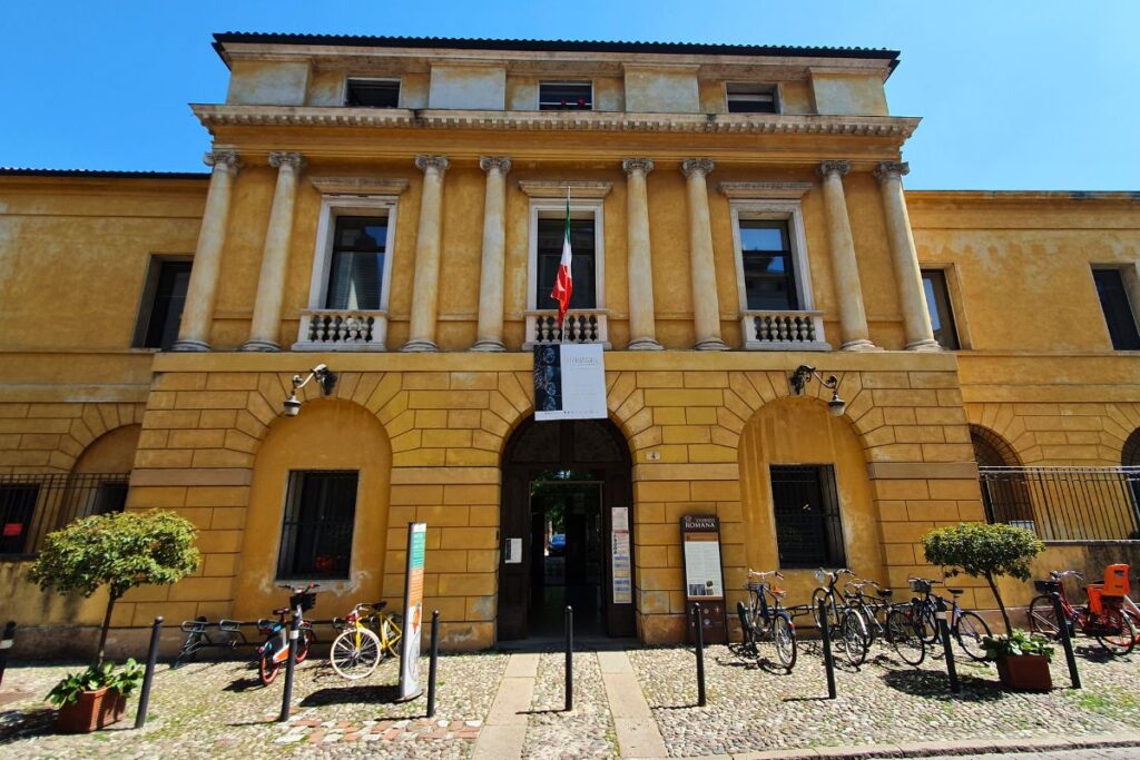 Die gelbe Fassade des naturkundlichen und archäologischen Museums in Vicenza mit Säulen und Fahrrädern davor.