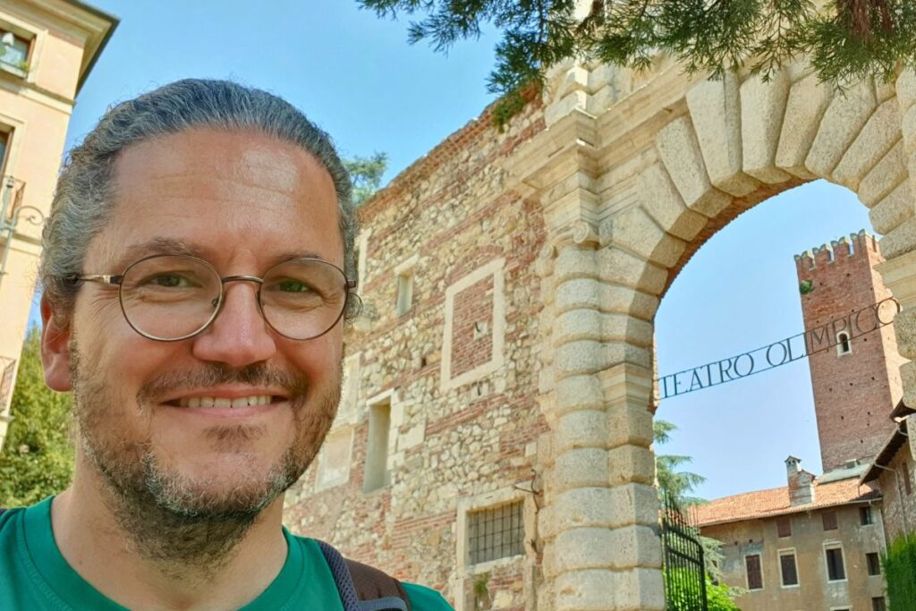 Selfie des Reisebloggers Nicolo Martin vor dem steinernen Eingangstor zum Teatro Olimpico in Vicenza, im Hintergrund der mittelalterliche Turm.