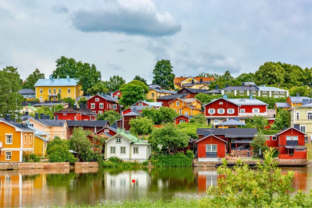 Die berühmten roten Holzhäuser am Flussufer in der Altstadt von Porvoo, die sich im Wasser spiegeln.