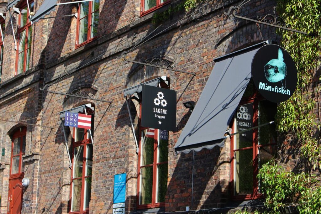 Rote Backsteinfassade der Sagene Bryggeri und das Schild des Kulturzentrums Månefisken mit Efeu bewachsen
