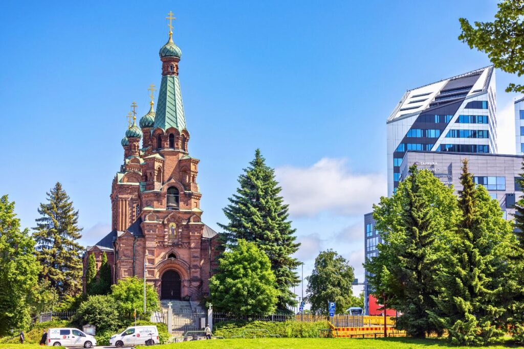 Die orthodoxe Kirche von Tampere mit ihren Zwiebeltürmen steht im Kontrast zur modernen Architektur der Nokia Arena im Hintergrund.