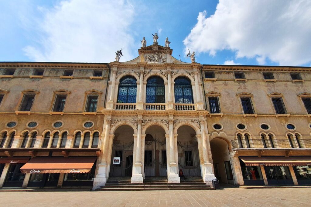Die elegante, in die Häuserzeile integrierte Fassade der Kirche San Vincenzo an der Piazza dei Signori mit drei hohen Bögen und Figuren auf dem Dach.