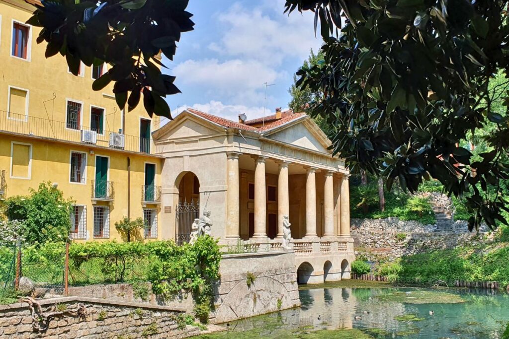 Die tempelartige Loggia Valmarana mit ihren sechs Säulen steht malerisch am Wasser im Park Giardino Salvi, umrahmt von Bäumen.