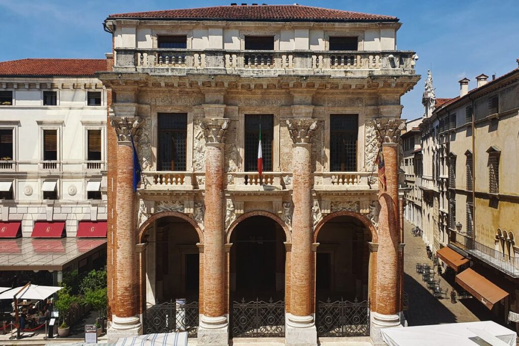Die markante rote Backsteinfassade der Loggia del Capitaniato mit ihren vier riesigen Säulen und Balkonen direkt an der Piazza dei Signori.