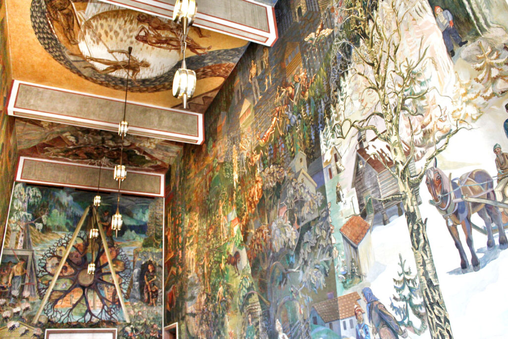 Farbenfrohe Wand- und Deckenmalereien im Inneren des Osloer Rathauses, die Szenen aus dem norwegischen Leben und der Arbeiterschaft zeigen