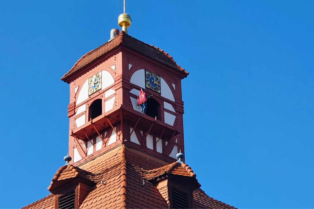 Die blau-rot gekleidete Symbolfigur „Dietemann“ bläst auf einem Balkon des Schlossturms in Eschwege in sein Horn.