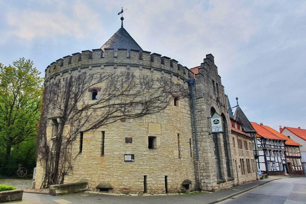 Das massive, historische Obertor in Northeim, ein Rundturm aus hellem Naturstein mit Zinnen.