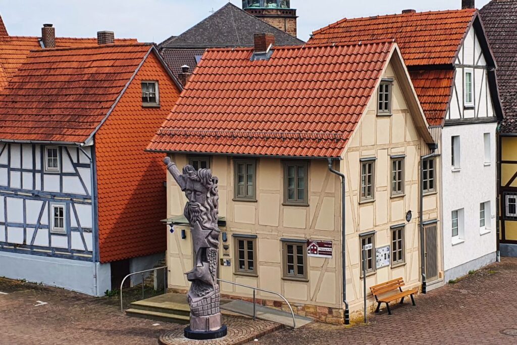 Das Jüdische Museum in Rotenburg an der Fulda in einem hellen Fachwerkhaus mit einer markanten Holzskulptur im Vordergrund.
