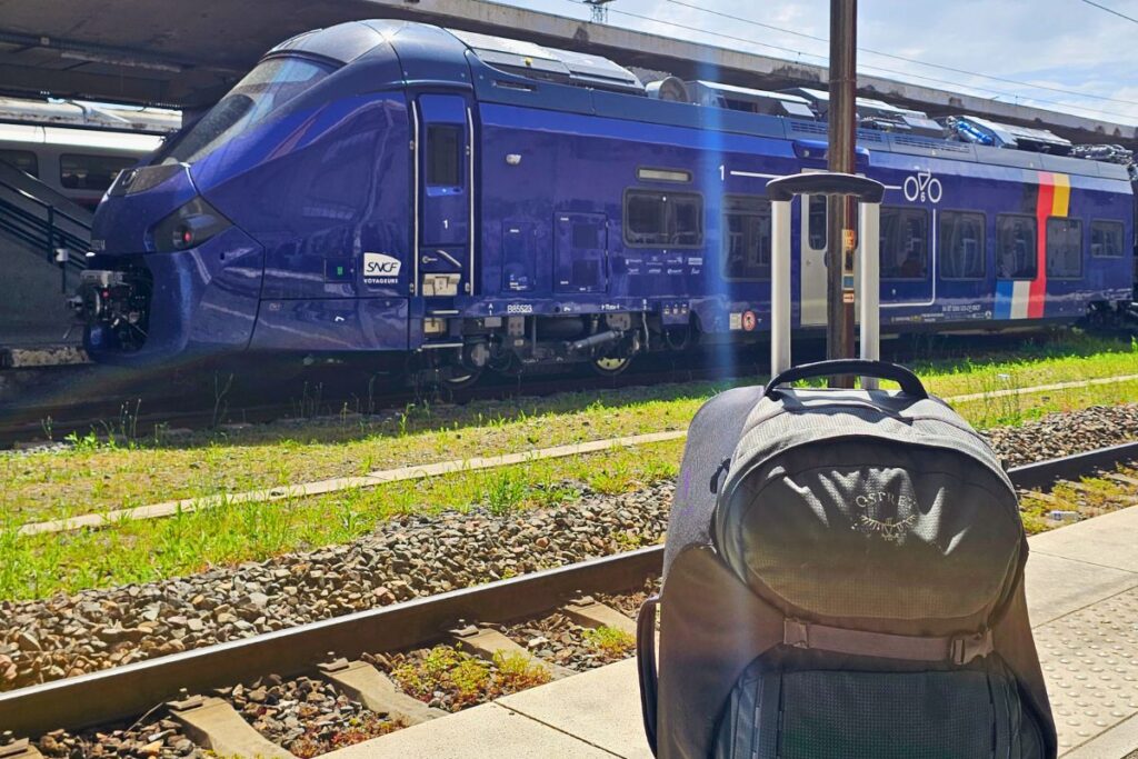 Ein blau-silberner Regionalzug steht in einem Bahnhof bereit für die Fahrt zwischen Deutschland und Frankreich.