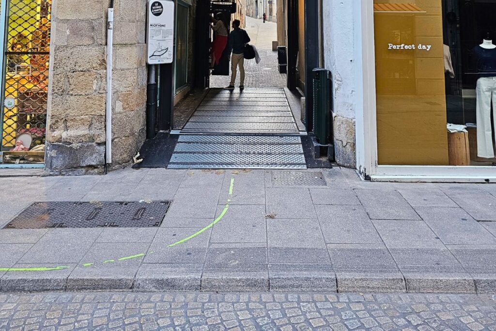 Eine leuchtend grüne Linie ist auf den grauen Steinplatten eines Gehwegs in Nantes markiert und führt Touristen durch die Gassen.
