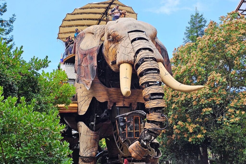 Ein riesiger, aus Holz und Stahl gefertigter mechanischer Elefant in den Machines de l'île in Nantes, auf dem Menschen mitfahren.