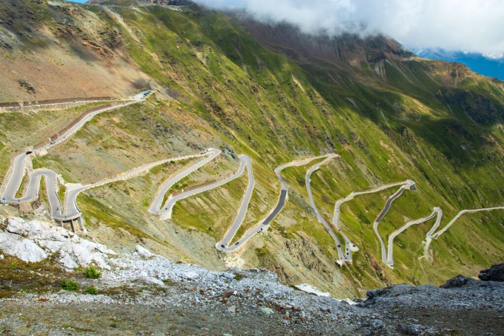 Die extrem gewundene Passstraße des Stilfserjochs in den italienischen Alpen mit zahlreichen Haarnadelkurven, die sich den Berghang hinaufziehen.