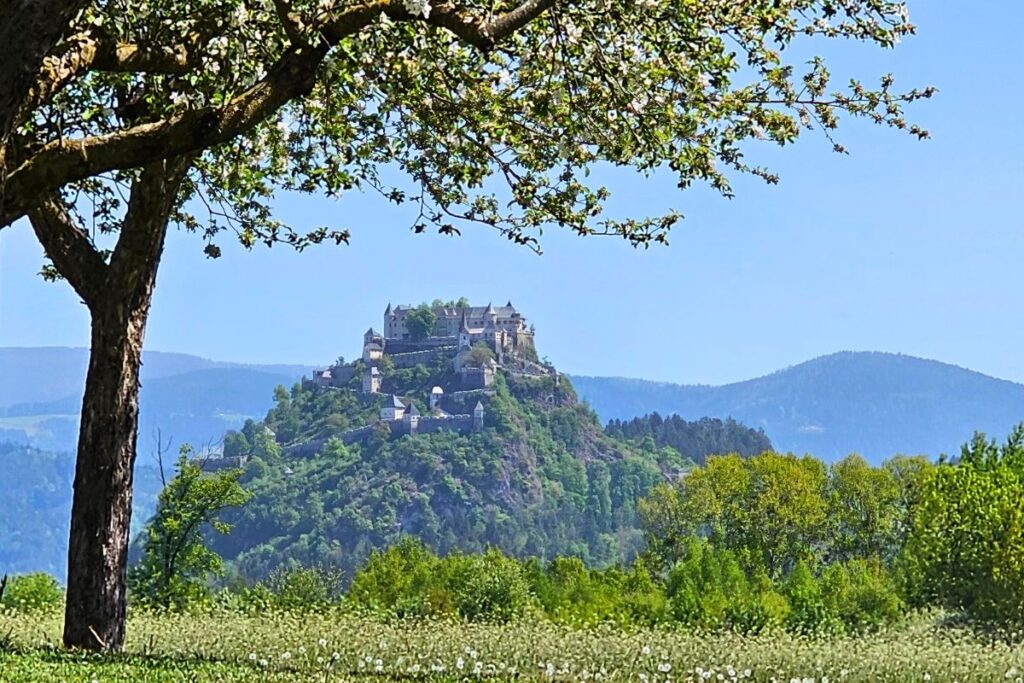 Die majestätische Burg Hochosterwitz thront weithin sichtbar auf einem hohen Felskegel über den Feldern und Radwegen Kärntens.