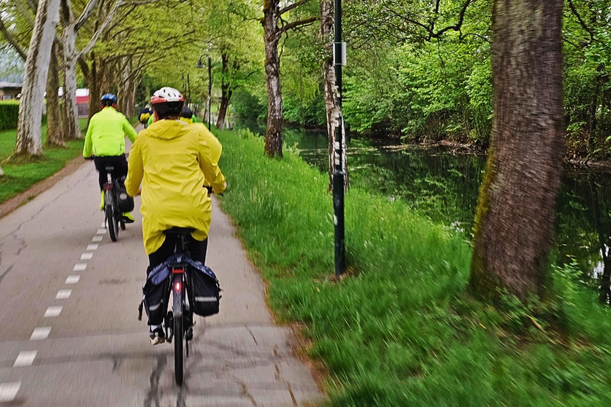 Der idyllische, von Bäumen gesäumte Lendkanal in Klagenfurt mit dem angrenzenden Radweg der Velovista-Tour.