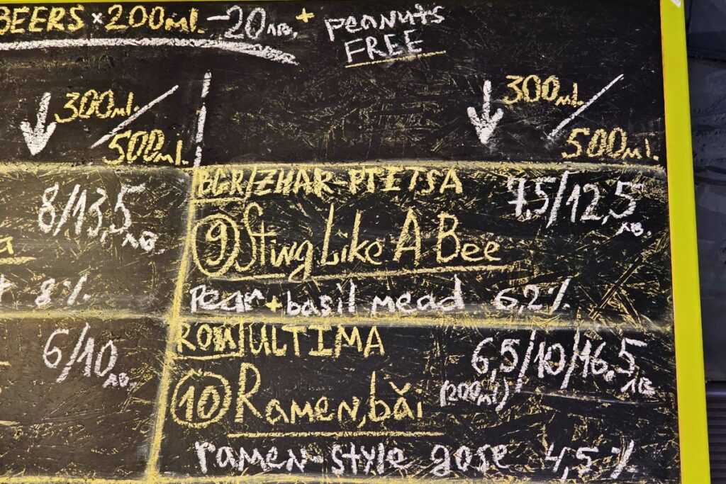 Eine schwarze Kreidetafel in einer Bar in Sofia zeigt handschriftlich Preise in bulgarischen Lewa für Tastings und Biere wie "Sting Like A Bee".