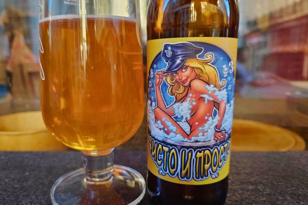 Ein gefülltes Bierglas neben einer Flasche "Chisto i Prosto" der Blek Pine Brewery mit einer gezeichneten Polizistin auf dem Etikett.