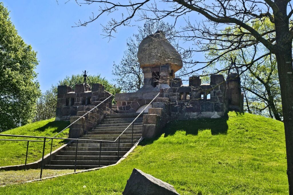 Das historische Landesdenkmal Dusenddüwelswarf bei Hemmingstedt auf einem grünen Hügel zur Erinnerung an die Schlacht im Jahr 1500.