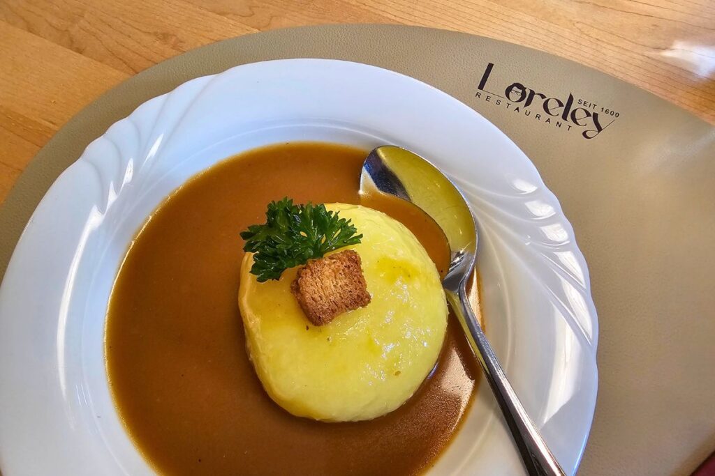 Ein Coburger Rutscher in sämiger Sauce mit Petersilie und einem gerösteten Crouton auf einem Teller mit Aufdruck Loreley Restaurant seit 1600.